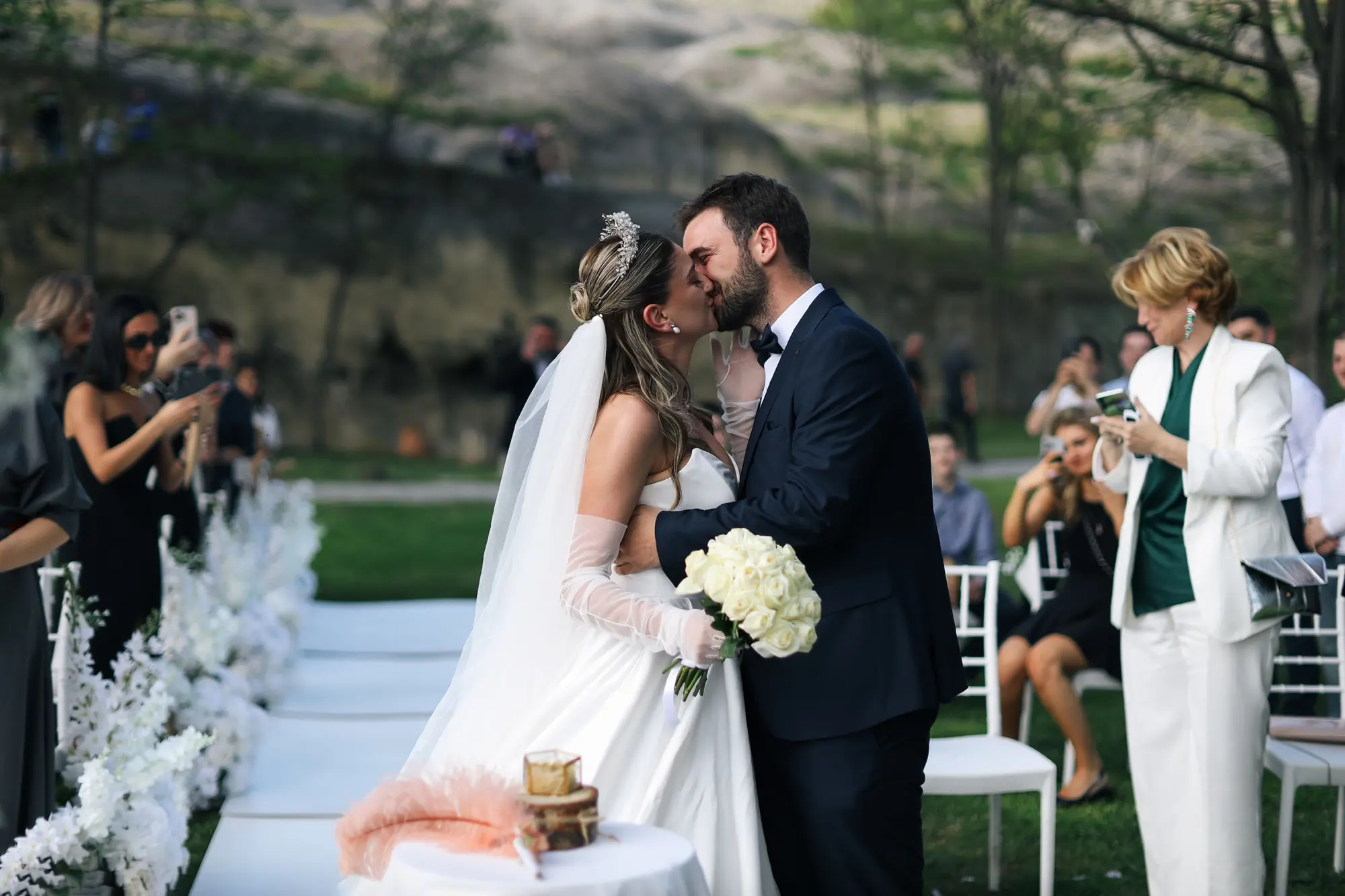 A couple sharing a kiss in a flower-lined aisle